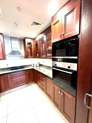 a kitchen with wooden cabinets and a black oven at 804 Yansoon 5 Amazing 1BR Apt Downtown Dubai in Dubai