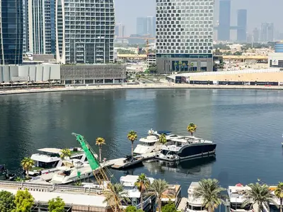 a group of boats docked in a river in a city at Chic 1-Bedroom with Epic Burj Khalifa Views in Dubai
