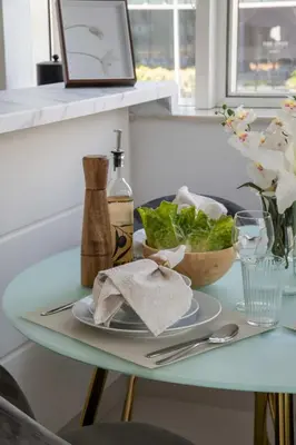 a table with a plate and a bowl of lettuce at Frank Porter - Damac Cour Jardin in Dubai