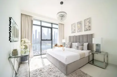 a white bedroom with a large bed and a large window at Frank Porter - Marina Vista Tower 2 in Dubai