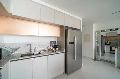 a kitchen with white cabinets and a stainless steel refrigerator at Frank Porter - Marina Vista Tower 2 in Dubai