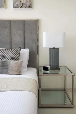 a bed with a glass table with a lamp on it at Frank Porter - Marina Vista Tower 2 in Dubai