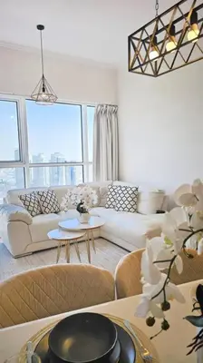 a living room with a couch and a table at Luxury 2BR Carson Tower B Apt in Dubai