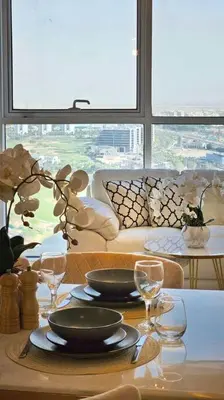 a table with plates and glasses on top of it at Luxury 2BR Carson Tower B Apt in Dubai