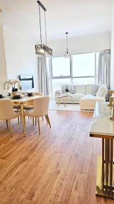 a living room with a table and chairs and a dining room at Luxury 2BR Carson Tower B Apt in Dubai