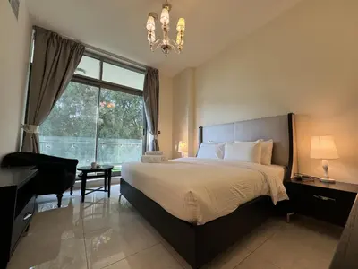 a bedroom with a bed and a large window at Dubai Apartment in Meydan in Dubai