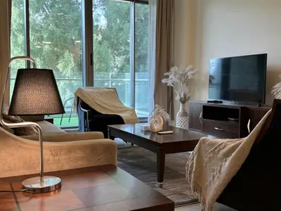 a living room with a couch and a tv at Dubai Apartment in Meydan in Dubai