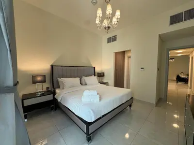a bedroom with a bed and a chandelier at Dubai Apartment in Meydan in Dubai