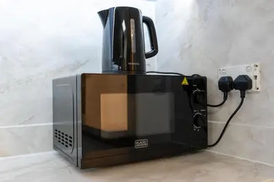 a microwave sitting on a counter next to a wall at Lux BnB I Executive Tower I Ocean View in Dubai