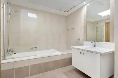 a white bathroom with a tub and a sink at Lux BnB I Executive Tower I Ocean View in Dubai