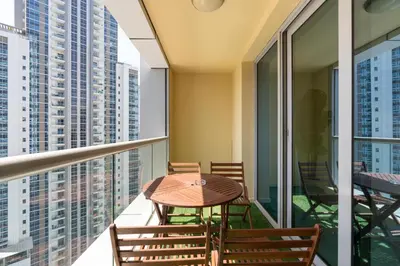 a balcony with a wooden table and chairs at Lux BnB I Executive Tower I Ocean View in Dubai