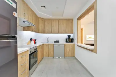 a kitchen with wooden cabinets and a sink at Lux BnB I Executive Tower I Ocean View in Dubai