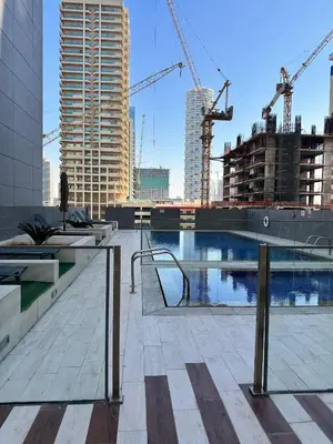 a view of a building with cranes in a city at Cozy Studio in JVC in Dubai