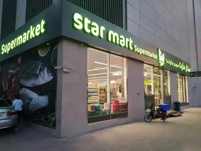 a star mart supermarket with a motorcycle parked outside of it at Cozy Studio in JVC in Dubai