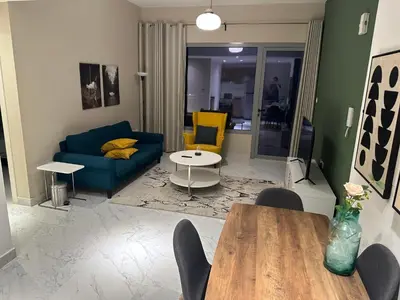a living room with a blue couch and a table at Nice 1BR in Dubai