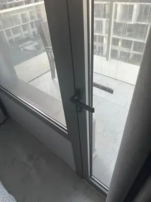 a sliding glass door with a handle on a window at Nice 1BR in Dubai