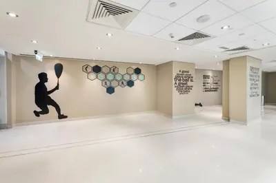 a room with a painting of a man holding a tennis racket at Burj Khalifa & Fountain View- 5mn walk to Dubai mall -Luxurious & Stylish 1BDR Apartment in Dubai