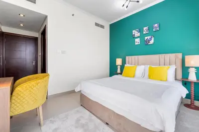 a bedroom with a bed and a table and a chair at Burj Khalifa & Fountain View- 5mn walk to Dubai mall -Luxurious & Stylish 1BDR Apartment in Dubai