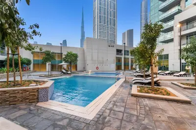 a pool in the middle of a city with tall buildings at Burj Khalifa & Fountain View- 5mn walk to Dubai mall -Luxurious & Stylish 1BDR Apartment in Dubai