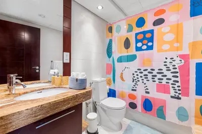 a bathroom with a toilet and a colorful wall at Burj Khalifa & Fountain View- 5mn walk to Dubai mall -Luxurious & Stylish 1BDR Apartment in Dubai