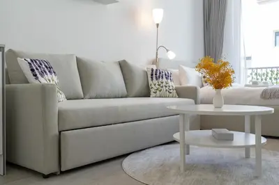 a living room with a couch and a table at Bright & Airy Studio in JVC in Dubai