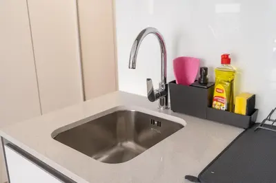 a kitchen sink with a faucet on a counter at Bright & Airy Studio in JVC in Dubai
