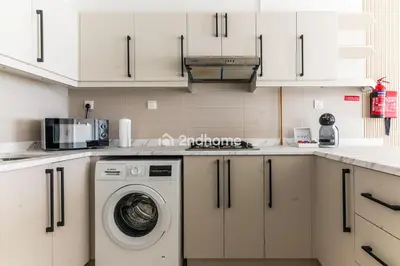 a kitchen with a washing machine and a microwave at Newly Furnished Unit in Elite, Business Bay in Dubai