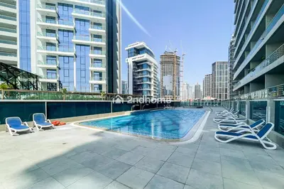a swimming pool on the roof of a building with lounge chairs at Newly Furnished Unit in Elite, Business Bay in Dubai