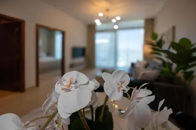 a vase with white flowers on a table in a living room at Brand new 1 bedroom in Marina gate 2, Dubai Marina in Dubai