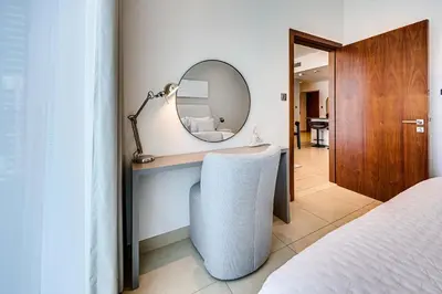 a bedroom with a vanity with a mirror and a chair at Brand new 1 bedroom in Marina gate 2, Dubai Marina in Dubai