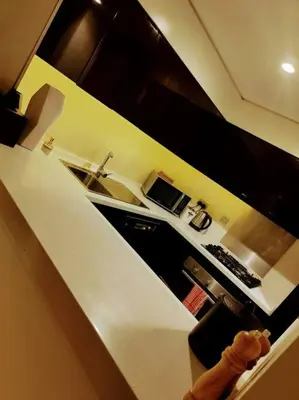 a kitchen with a white counter top and a microwave at Luxury 1BR Majestine Apartment in Dubai