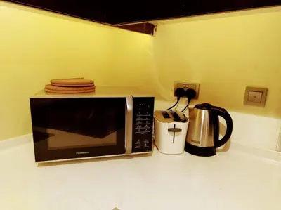 a microwave sitting on a counter next to a coffee maker at Luxury 1BR Majestine Apartment in Dubai