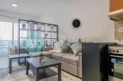 a living room with a couch and a table at Bloomfields Stu Lago With Vista Sea View in Dubai