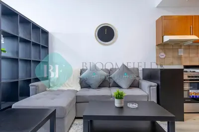 a living room with a couch and a table at Bloomfields Stu Lago With Vista Sea View in Dubai