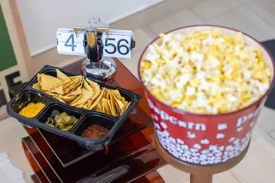 a table with a container of food and a bucket of chips at 2035-Inspired 1BR - JVC Dubai Near Burj Khalifa in Dubai