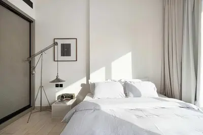 a white bedroom with a bed and a lamp at 2035-Inspired 1BR - JVC Dubai Near Burj Khalifa in Dubai