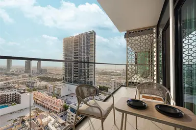 a balcony with a table and chairs and a view of a city at 2035-Inspired 1BR - JVC Dubai Near Burj Khalifa in Dubai