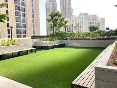 a green lawn in a city with benches and buildings at Classy 1BR Apartment at Creek Horizon Tower 1, Dubai Creek Harbour by Deluxe Holiday Homes in Dubai