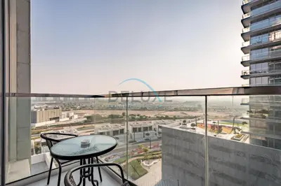 a balcony with a table and chairs on a building at Stunning 1BR Apartment in District One Phase III, Mohammed Bin Rashid by Deluxe Holiday Homes Al Maktoum City in Dubai