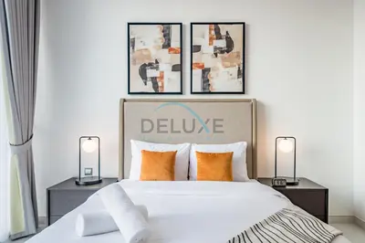 a bedroom with a large bed with two lamps at Stunning 1BR Apartment in District One Phase III, Mohammed Bin Rashid by Deluxe Holiday Homes Al Maktoum City in Dubai