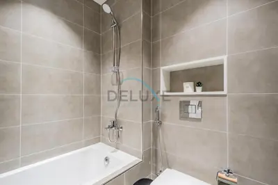 a bathroom with a shower with a toilet and a tub at Stunning 1BR Apartment in District One Phase III, Mohammed Bin Rashid by Deluxe Holiday Homes Al Maktoum City in Dubai