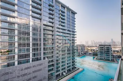 a large apartment building with a pool in front of it at Stunning 1BR Apartment in District One Phase III, Mohammed Bin Rashid by Deluxe Holiday Homes Al Maktoum City in Dubai