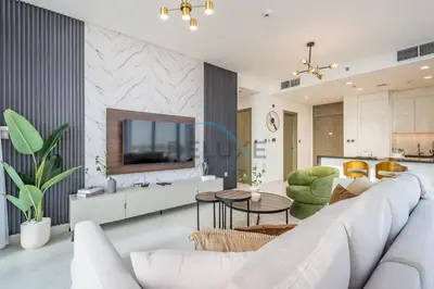 a living room with a white couch and a tv at Stunning 1BR Apartment in District One Phase III, Mohammed Bin Rashid by Deluxe Holiday Homes Al Maktoum City in Dubai