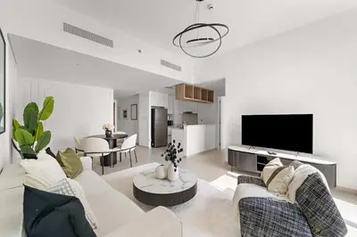 a living room with white furniture and a flat screen tv at Silkhaus Full Burj Khalifa Views in Downtown in Dubai