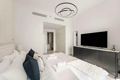 a living room with a white couch and a flat screen tv at Silkhaus Full Burj Khalifa Views in Downtown in Dubai