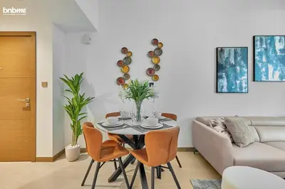 a living room with a table and chairs and a couch at bnbmehomes - Urban Oasis by Missoni in Dubai