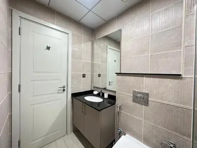 a bathroom with a white door and a sink at Stunning 1-Bedroom in The Polo Residence, Meydan in Dubai