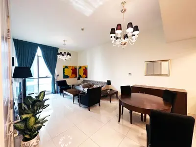 a living room with a table and a dining room at Stunning 1-Bedroom in The Polo Residence, Meydan in Dubai