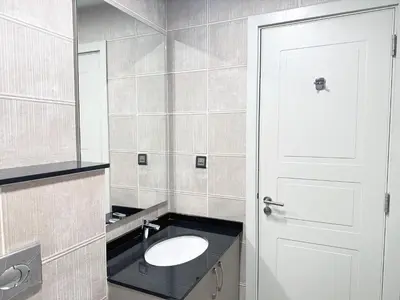 a bathroom with a sink and a white door at Stunning 1-Bedroom in The Polo Residence, Meydan in Dubai