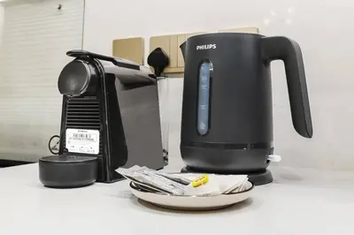 a coffee maker sitting on a counter next to a plate at FIRST CLASS 1BR Heart of Tranquility in Dubai